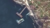 На спутниковом снимке плавучий кран (больше по размеру), десантный корабль класса Serna и затонувший российский корабль класса Serna. Остров Змеиный, Украина, 12 мая 2022 года. Изображение Maxar Technologies 