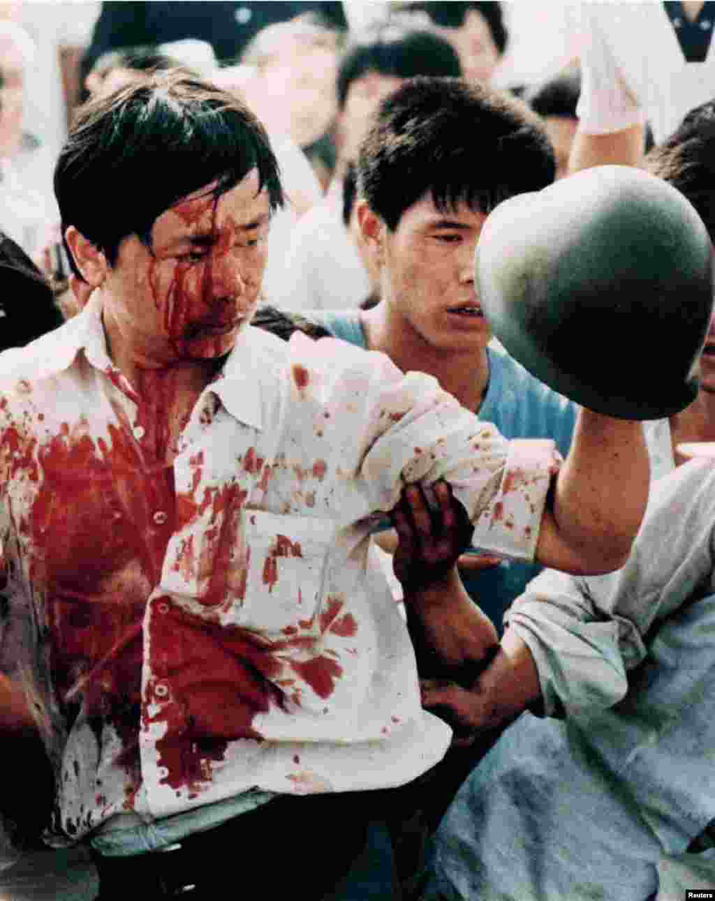 A blood-covered protester holds a Chinese soldier&#39;s helmet following violent clashes with military forces on June 4. The crackdown killed hundreds of civilians -- and by some estimates, thousands. Dozens of servicemen were also reported killed.