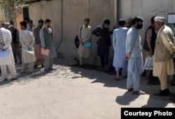 Ethnic Kazakh Afghans wait outside the Kazakh Embassy in Kabul on September 5.