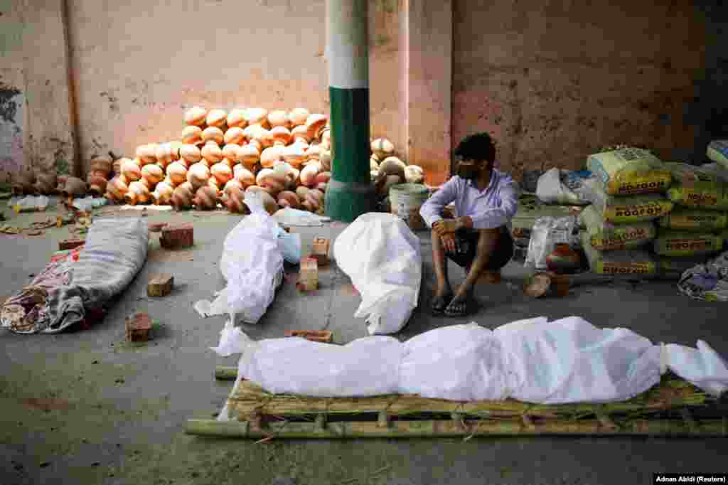 Ky person në Nju Delhi qëndron pranë disa trupave të pajetë, që janë sjellë në një krematorium më 26 prill.&nbsp; 