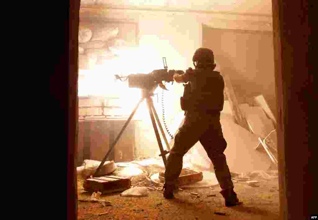 A Ukrainian government soldier fires a heavy machine gun during a battle with pro-Russia separatists at Avdiyivka in Ukraine's eastern Donetsk region. (AFP/Anatolii Stepanov)