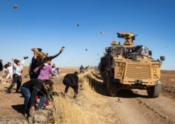 Курды на севере Сирии забрасывают камнями совместный российско-турецкий военный патруль. 8 ноября 2019 года.