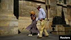 Doi turiști cu pălării la Catedrala Sf. Ștefan din Viena, pe 3 august 2026.