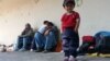 Children and parents rest at a train station in Demir Kapija on their way to the Serbian border on June 15.&nbsp;​Macedonia&#39;s Interior Ministry says the number of illegal migrants has quadrupled in the past four months. Thousands of migrants are now entering the country every week, officials say.