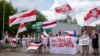 Протестувальники у Литві тримають плакати з написами «Ви знаєте, що робити», «Лукашенко – терорист» та біло-червоно-білі прапори під час акції протесту з вимогою звільнити політичних в’язнів у Білорусі, 8 червня 2021 року