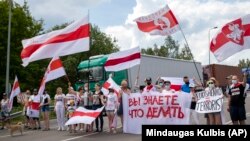 Протестувальники у Литві тримають плакати з написами «Ви знаєте, що робити», «Лукашенко – терорист» та біло-червоно-білі прапори під час акції протесту з вимогою звільнити політичних в’язнів у Білорусі, 8 червня 2021 року