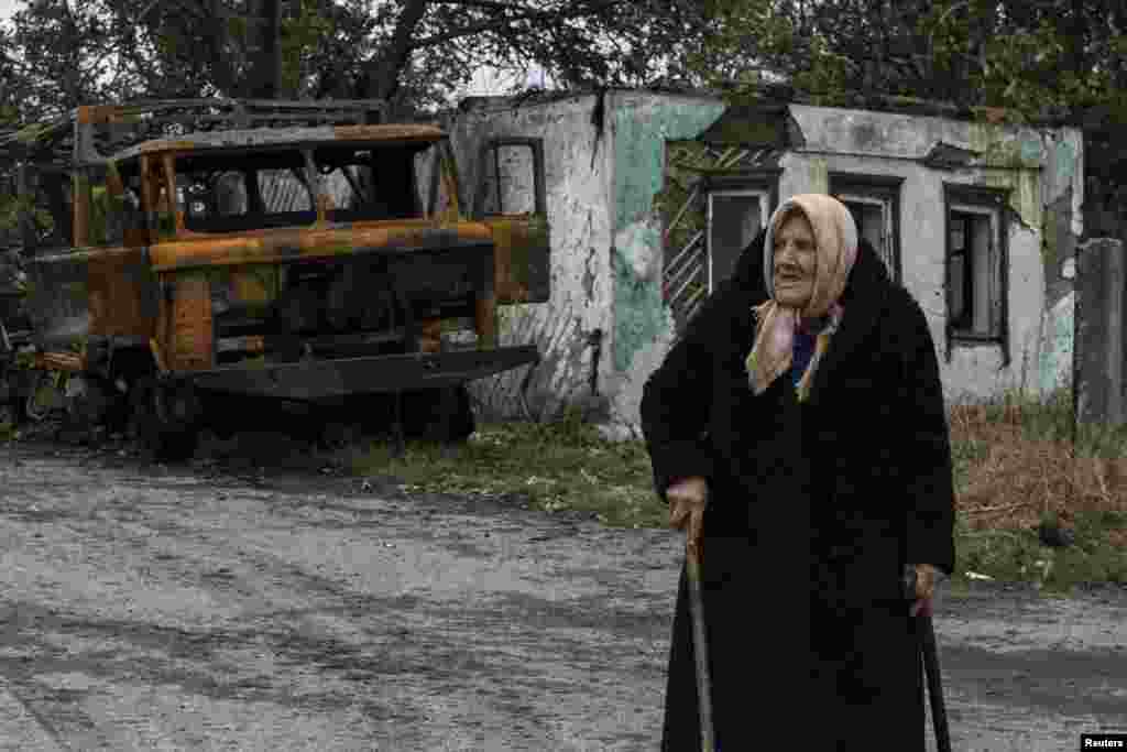 Şərqi Ukraynada Ilovaysk şəhərində yanmış hərbi texnikanın yanından keçən şəhər sakini, 25.09.2014&nbsp;(Reuters/Marko Djurica) 