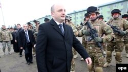 Georgian Fefense Minister Mindia Janelidze (C) inspects Georgian soldiers during a farewell ceremony marking their departure to Afghanistan, at the military base of Vaziani outside Tbilisi on December 16, 2014.