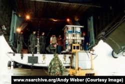 Metal barrels containing uranium being loaded aboard an American transporter aircraft during Project Sapphire