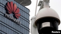 FILE PHOTO: A surveillance camera is seen in front of the Huawei logo outside its factory campus in Dongguan, Guangdong province, China, March 25, 2019. REUTERS/Tyrone Siu/File Photo