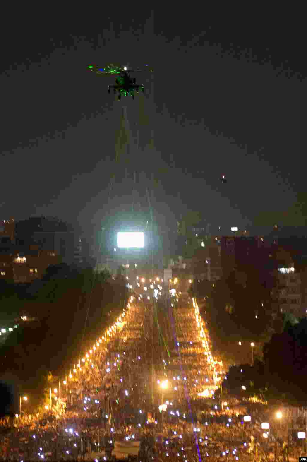 Protesters direct laser lights onto a military helicopter flying over the presidential palace in Cairo, as hundreds of thousands of Egyptians gathered to call for the ouster of President Muhammad Morsi. (AFP/Khaled Desouki)