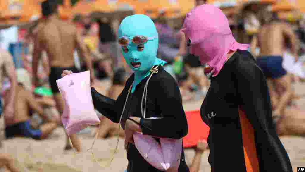 Beachgoers in Chinea wear body suits and protective head masks, dubbed &quot;facekinis&quot; by Chinese netizens, on a crowded public beach in Qingdao in the northeastern Shangdong province on August 19. (AFP)