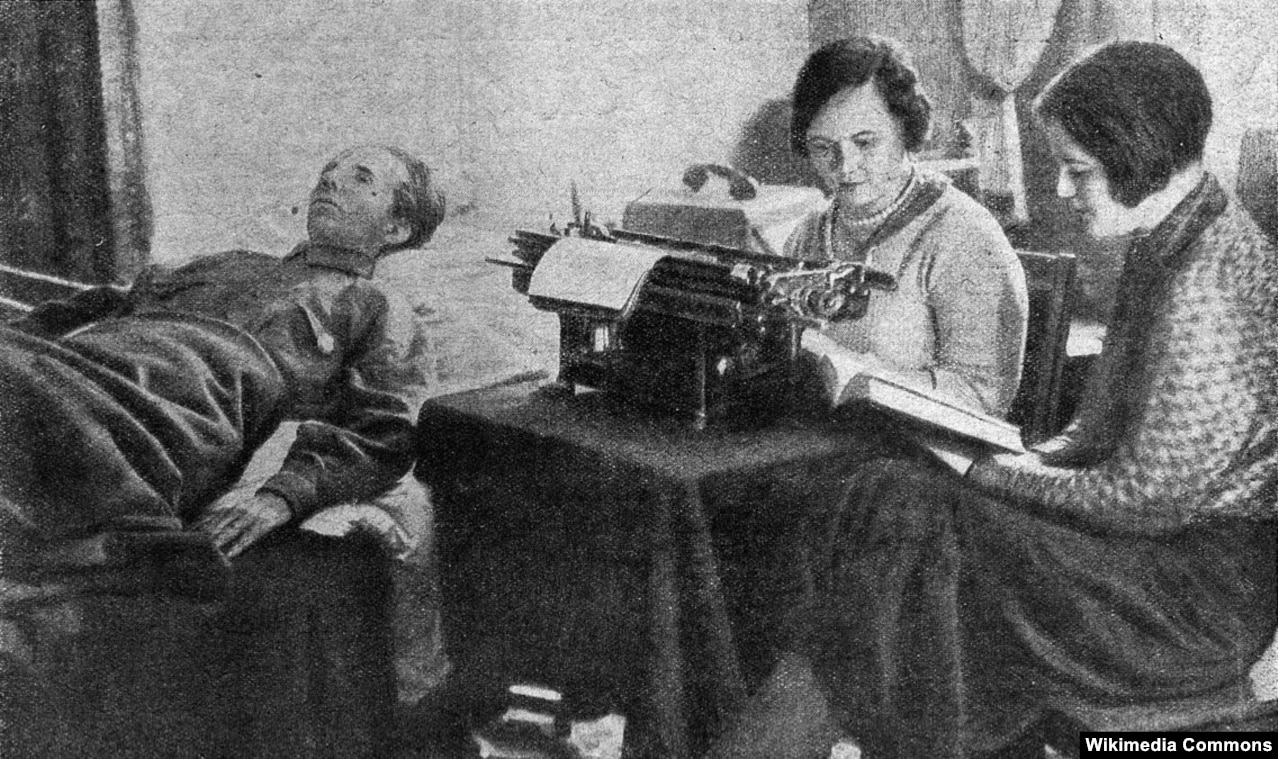 Пропагандистське постановочне радянське фото. Письменник Микола Островський в робочій обстановці. Праворуч із книгою в руках його дружина Раїса Островська