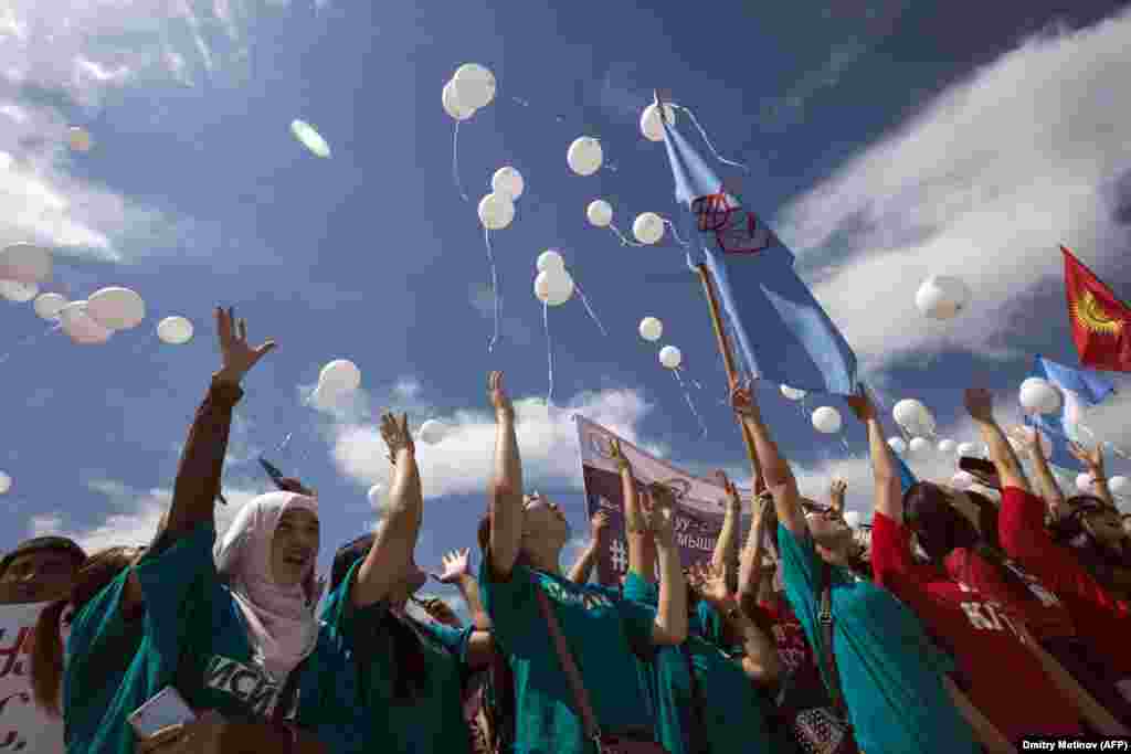 Kyrgyz students release white balloons as they protest against bride kidnapping in Bishkek after a 20-year-old woman was murdered in a police station by her kidnapper. (AFP/Dmitry Motinov)