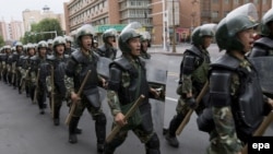 Forțele de securitate chineze în marș pe o stradă din Xinjiang