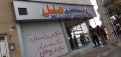 A damaged credit union branch in Shiraz, Iran. Slogan says, "Death to Khamenei", "Death to Rouhani".