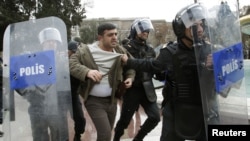 Azerbaijan -- Police officers detain one of the opposition activists during an unauthorized rally in central Baku, 26Jan2013