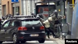 Belgium -- Armed Belgian police apprehend a suspect, in this still image taken from video, in Molenbeek, near Brussels, March 18, 2016