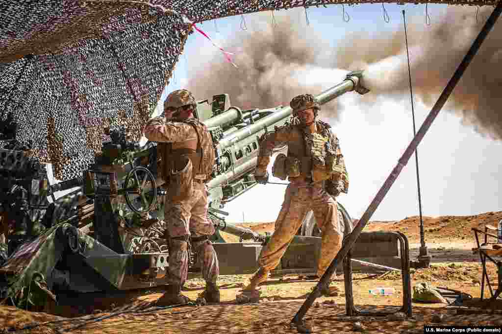 Pușcași marini trăgând o salvă de tun în timpul luptelor din norul Siriei în martie 2017. Trupele americane au operat în Siria de la începutul lui 2016.