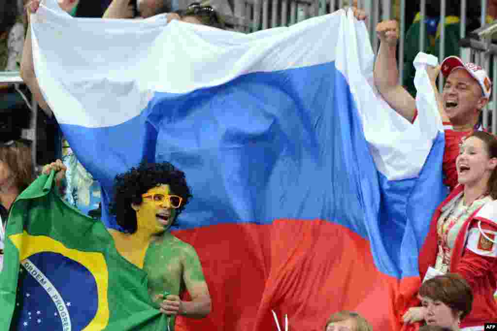 Болельщики сборных России и Бразилии пытаются перекричать друг друга на матче своих сборных по волейболу. 