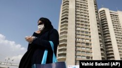 A pedestrian wearing a face mask crosses a street in northern Tehran on March 1.