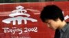 China -- A pedestrian walks past a banner promoting the Beijing 2008 Olympic Games tickets in Beijing, 15Apr2007