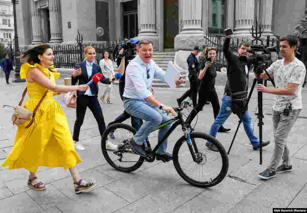 Radical Party leader Oleh Lyashko speaks with journalists as he rides a bicycle after newly inaugurated Ukrainian President Volodymyr Zelenskiy held consultations with lawmakers, near the presidential administration headquarters in Kyiv on May 21. (Reuters/Gleb Garanich)