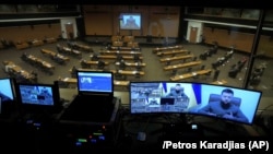 Президент України Володимир Зеленський (на екрані) під час звернення через відеозв'язок до парламенту Кіпру. Нікосія, 7 квітня 2022 року 