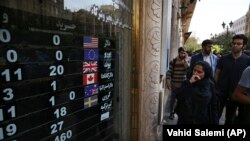 People are wondering how much their national currency has fallen, in downtown Tehran, October 2, 2018