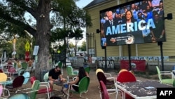 O reclamă electorală cu vicepreședinta SUA și candidata democrată la președinția SUA, Kamala Harris, difuzată la TV în pauza unui meci de fotbal urmărit pe o terasă în San Antonio, Texas.