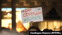 Участник в протеста заради атаката срещу Конституционния съд в София на 12 март държи плакат с надпис "Кой открадна изборите"