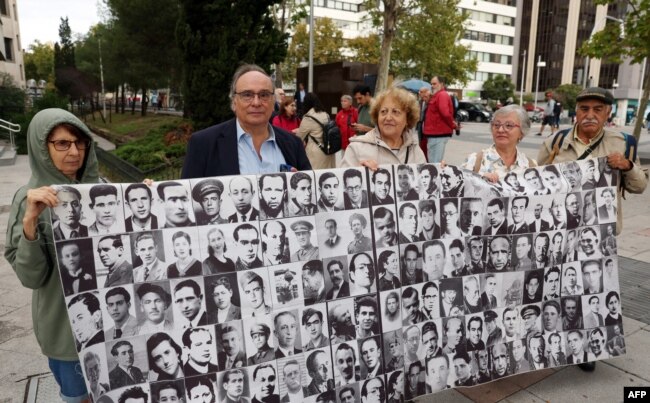 گروهی از قربانیان دیکتاتوری فرانکو با تصاویری از دیگر قربانیان بیرون دادگاهی در مادرید، سپتامبر ۲۰۲۳