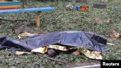 The body of a local resident killed in a Russian missile strike lies covered on a playground at an apartment building damaged during a Russian missile strike on Mykolayiv on July 19. Three people were killed, including a child.