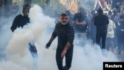 Demonstrant nosi kanistar sa suzavcem tokom antivladinih protesta studenata u Tirani, Albanija, 24. oktobra 2026. godine.