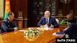 Belarusian President Alyaksandr Lukashenka meets with newly appointed Interior Minister Ivan Kubrakou (left) in Minsk on October 29. 