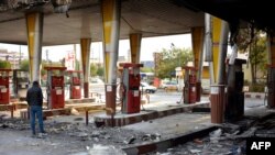 Iran -- An Iranian man checks a scorched gas station that was set ablaze by protesters during a demonstration against a rise in gasoline prices in Eslamshahr, near the Iranian capital of Tehran, on November 17, 2019. - President Hassan Rouhani warned tha