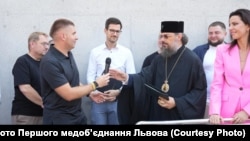 Олег Самчук передає мікрофон митрополиту УПЦ Філарету