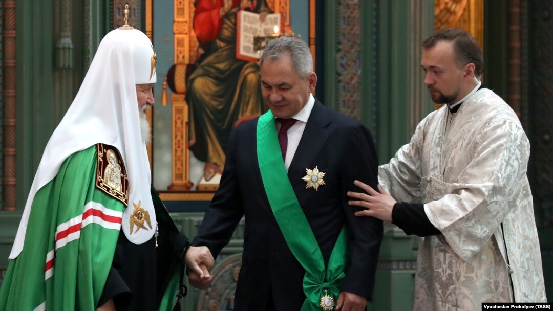 Patriarch Kirill (left) bestows an award on Russian Defense Minister Sergei Shoigu (center) in June 2021.