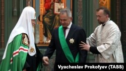 Patriarch Kirill (left) bestows an award on Russian Defense Minister Sergei Shoigu (center) in June 2021.