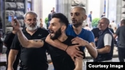 "იმედში" გადასვლამდე, ჟურნალისტი ლეო სიხარულიძე [შავი მაისურით] "ევრონიუსში" მუშაობდა. ის კულტურის ყოფილი მინისტრის, თეა წულუკიანის ყოფილი მოადგილის, კარლო (კახა) სიხარულიძის ვაჟია. მასთან ერთად კადრში ჩანს ალექსანდრე მუკათარიძე, თბილისის საკრებულოს დეპუტატობის კანდიდატი. 