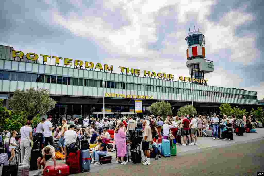 Aerportul din Rotterdam, Olanda. Călătorii stau în fața aeroportului din cauza întârzierilor generate de căderea cibernetică. 19 iulie 2024.