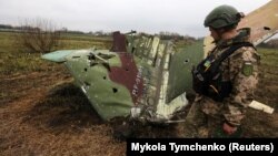 Ілюстраційне фото. Український військовий біля літака Су-25, збитого в Київській області, квітень 2022 року