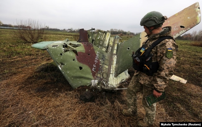 Український військовий сапер оглядає те, що лишилось від російського бойового літака Су-25, збитого ЗСУ на Київщині, 21 квітня 2022 року