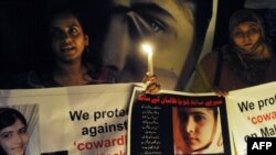 Pakistani civil society activists carry candles to pay tribute to Malala Yousafzai in Lahore.