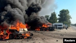 Vehicles burn after a Russian strikes on the town of Pechenihy in the Kharkiv region that killed at least 10 people on August 18. 