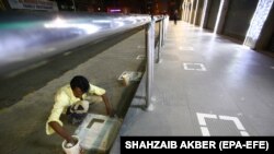 A man paints areas to maintain social distancing outside a shopping center in Karachi after the Pakistani government eased lockdown restrictions on May 17.