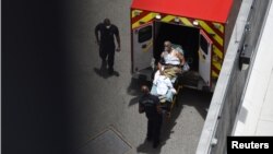Хьюстонда COVID-19 инфекциясига чалинган бемор "тез ёрдам" машинасидан туширилмоқда, Техас, 2020 йил 28 июни.