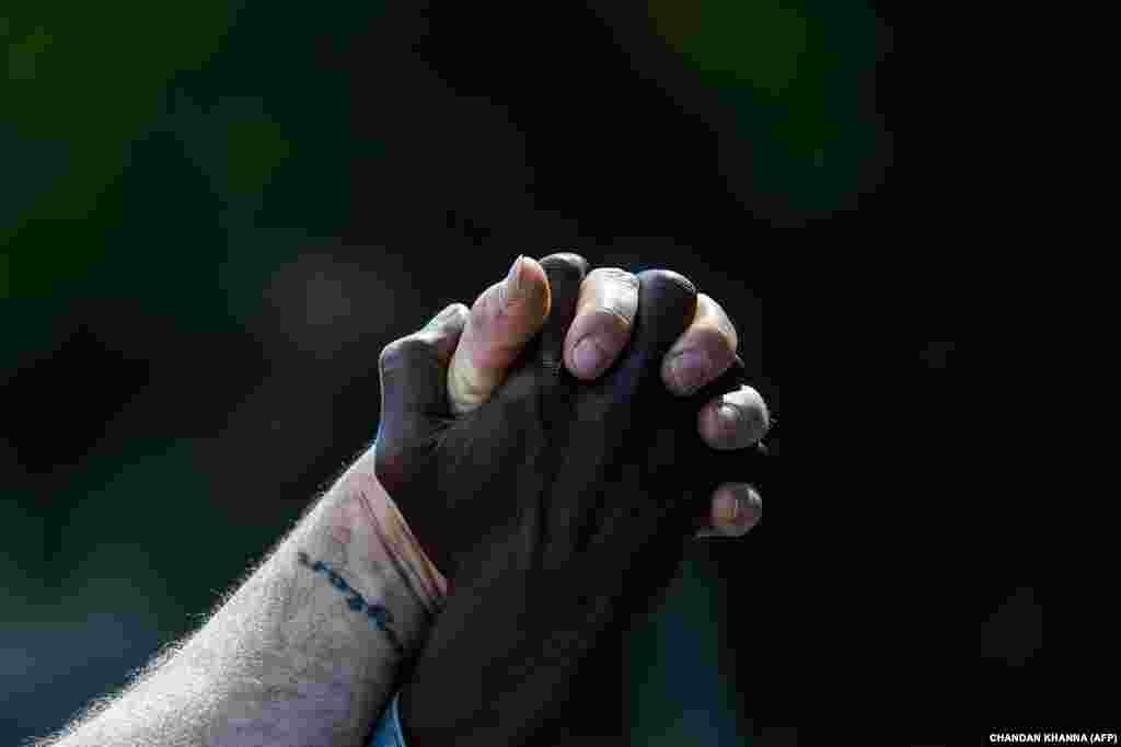 Protesters hold hands as they protest on the fourth day on the fourth day following Rayshard Brooks' shooting death by police in a Wendy's restaurant parking lot, June 16, 2020, in Atlanta, Georgia. The fatal shooting of Brooks, a black man, by a white police officer in Atlanta has poured more fuel on the raging US debate over racism, prompting another round of street protests and the resignation of the southern city's police chief. The death of 27-year-old Rayshard Brooks was ruled a homicide by the county medical examiner's office on June 14, 2020, a day after the Wendy's restaurant where he died was set on fire and hundreds of people marched to denounce the killing.