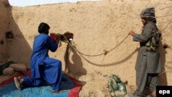 FILE: Afghan Local Police (ALP) take positions during an operation against Taliban militants in Sangin district of restive Helmand Province on January 31.