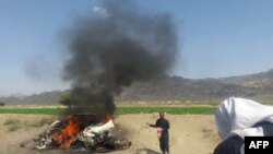 A car is seen on fire at the site of a drone strike believed to have killed Afghan Taliban leader Mullah Akthar Mansur in southwest Pakistan.